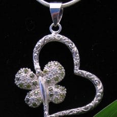 Handcrafted 925 sterling silver openwork heart pendant featuring Balinese scrollwork engraving and a pave-set peridot and clear gemstone butterfly accent.