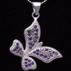 Handcrafted 925 sterling silver butterfly pendant set with rich purple amethyst-colored gemstones in a pave setting with beaded silver wing borders.
