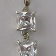 Front view of an artisan 925 sterling silver drop pendant featuring two princess-cut clear cubic zirconia gemstones in four-prong settings.