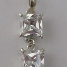 Front view of an artisan 925 sterling silver drop pendant featuring two princess-cut clear cubic zirconia gemstones in four-prong settings.