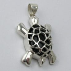 Top view of an artisan-crafted 925 sterling silver sea turtle pendant featuring a cage-style shell encasing a smooth black onyx gemstone.