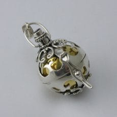 Handcrafted 925 sterling silver spherical harmony ball pendant featuring intricate Balinese scrollwork cutouts, oxidation details, and a polished inner brass chime sphere.