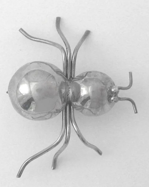 An artisan-crafted 925 sterling silver spider brooch featuring a highly polished, two-part rounded body with curved hand-forged silver wire legs.