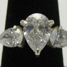 Front macro view of a handcrafted 925 sterling silver trilogy ring featuring a large center pear-cut clear zircon flanked by two smaller pear-shaped gemstones in multi-prong claw settings.