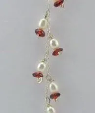 Alternate angle of the long Balinese 925 sterling silver dangle earring displaying a cascading vine chain of freshwater pearls and amber rondelles.