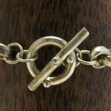 Artisan-crafted 925 sterling silver heavy rollo chain bracelet featuring a polished T-bar toggle ring clasp on a dark wood display.