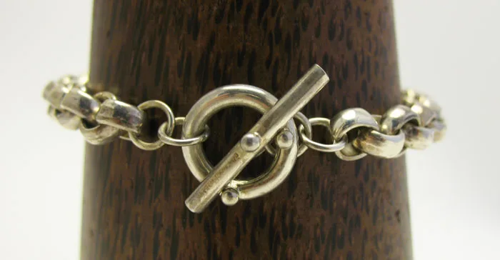 Artisan-crafted 925 sterling silver heavy rollo chain bracelet featuring a polished T-bar toggle ring clasp on a dark wood display.