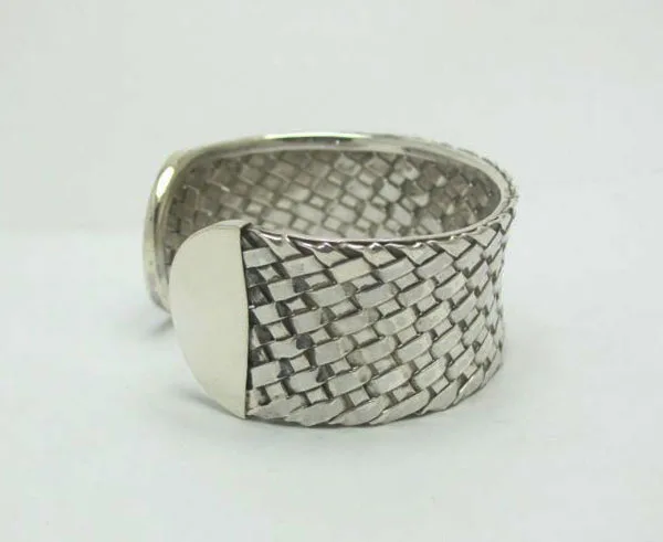 Side perspective view of the hand-forged 925 sterling silver basketweave cuff bracelet highlighting the smooth solid end caps and internal woven texture.