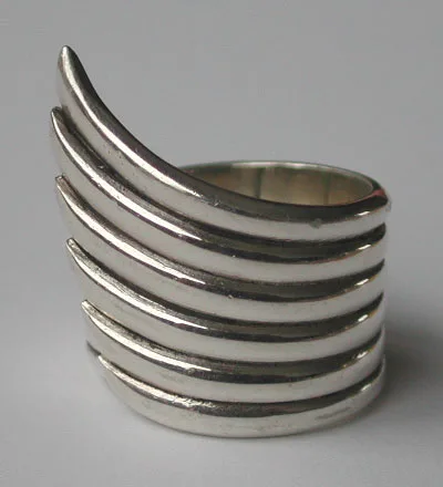 A close-up front view of a sculptural 925 sterling silver ring featuring a layered angel wing design with smooth, polished bands, captured in an artisan-crafted style against a neutral background.