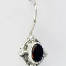 Front view of a 925 sterling silver drop earring featuring an oval dark red faceted gemstone in a bezel setting with four silver dot accents.