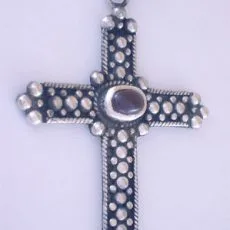 Artisan-crafted 925 sterling silver cross pendant decorated with extensive silver granulation work and a central oval red garnet gemstone.