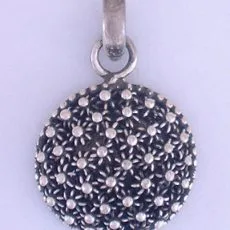 Round handmade sterling silver pendant featuring an intricate floral janger pattern with a dark oxidized background.