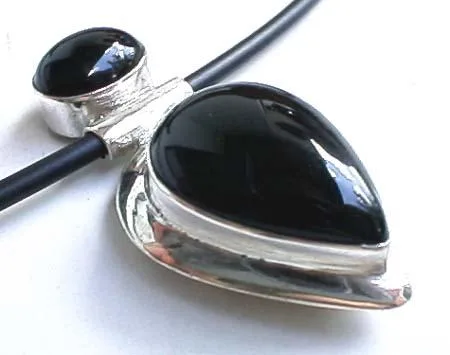 Side profile of a dual-stone black onyx pendant showcasing polished 925 sterling silver bezel settings.