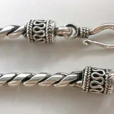 Artisan-crafted 925 sterling silver twisted foxtail chain necklace highlighting the hand-forged S-hook clasp and detailed wave-pattern filigree end caps.