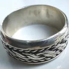 Artisan-crafted 925 sterling silver wide band ring featuring an intricate Balinese braided chain motif with a detailed oxidized background and smooth polished borders, captured from a close-up three-quarter angle.