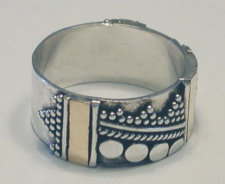 Artisan-crafted wide 925 sterling silver band ring featuring panels of gold-toned metal accents and intricate Balinese jawan granulation motifs.