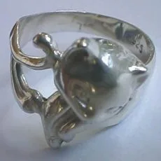 An unedited shot of a polished 925 sterling silver wrap ring designed in the shape of a curling cat, highlighting its smooth reflective finish on a light grey background.