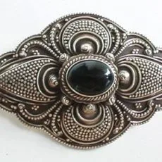 An elegant marquise-shaped 925 sterling silver brooch featuring a polished oval black onyx gemstone center surrounded by detailed Balinese jawan beadwork and oxidized accents