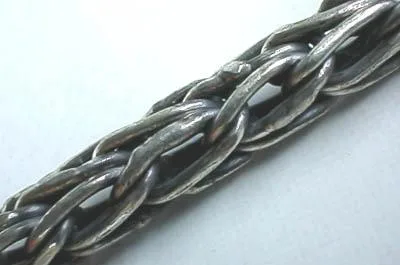 Macro view of the detailed hand-forged weave patterns on a 925 sterling silver foxtail chain necklace.