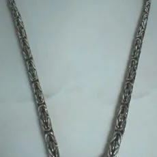Artisan-crafted 925 sterling silver Byzantine link chain necklace laid out on a smooth surface.