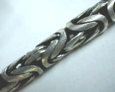Macro view highlighting the intricate, interwoven links of a Balinese-style 925 sterling silver Byzantine chain.