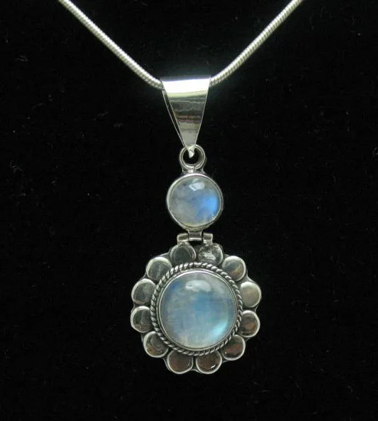 Centered close-up of a handcrafted 925 sterling silver sunburst pendant featuring two tiers of glowing, round rainbow moonstone cabochons.