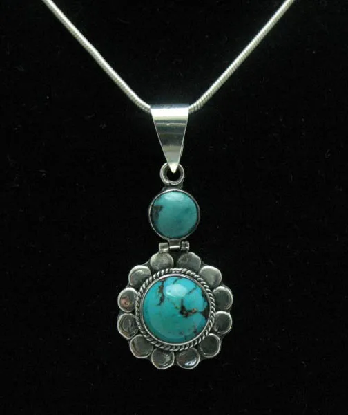 Direct front-facing studio shot of the Bali-style sterling silver two-tier pendant highlighting a stacked pair of round sky-blue turquoise gemstones.