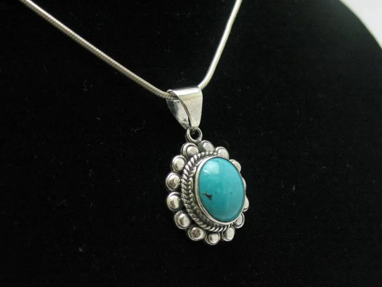 Side perspective of an artisan 925 sterling silver pendant featuring a sky-blue oval turquoise cabochon on a fine snake chain.