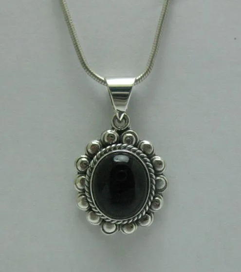 Front view of a handcrafted sterling silver sunburst pendant showcasing a smooth black onyx stone surrounded by a rope border and silver beads.