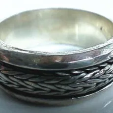 Hand-forged 925 sterling silver spinner ring featuring an intricate oxidized woven braid center bordered by smooth, polished silver edges.