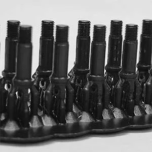 A macro shot of high-precision 3D printed liquid resin jewelry master models featuring fine threaded structural components organized on a production printing bed.