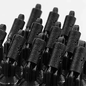 A close-up view of a high-resolution 3D printed resin jewelry prototype array showcasing multiple detailed cylindrical master components with decorative star cutouts and top loops on support structures.